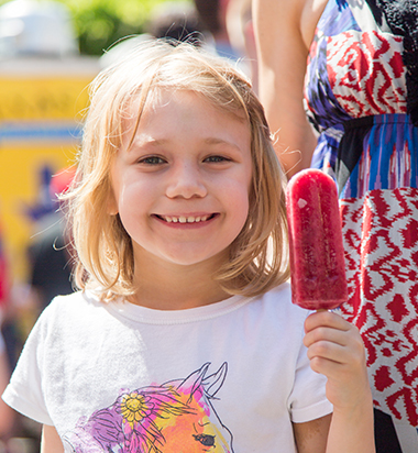 smiling young girl holding a streetpops ice pop – streetpops make great fundraisers for Cincinnati school and community organizations